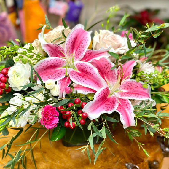 Bouquet of pink lilies, white roses, and other flowers.